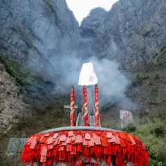 Un gran incensario con amuletos rojos cuelga ante la **puerta del cielo china**, una abertura natural en la montaña.