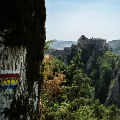 Marqueurs de sentier sur un arbre, indiquant le chemin vers un château perché sur une falaise. Quel est le gr le plus difficile à atteindre ?