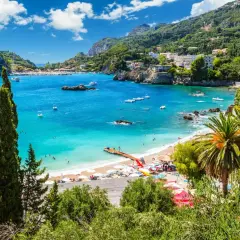 Traumhafte Bucht mit türkisfarbenem Wasser, Palmen und einem Steg. Perfekt für Korfu Reisetipps und einen entspannten Urlaub.