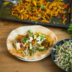 En läcker kyckling shawarma fylld med grönsaker och sås, serverad med pitabröd och en fräsch sallad.