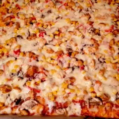 Pyszna pizza domowa na blachę z kurczakiem, kukurydzą i pieczarkami, obficie posypana serem. Idealna na rodzinny obiad.