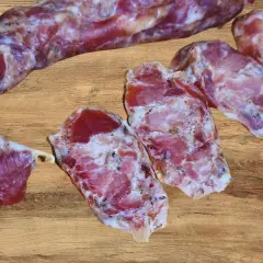 Kiełbasa dojrzewająca, pokrojona w plastry, prezentuje swoje aromatyczne wnętrze. Idealna do domowego wyrobu, gdy szukasz sprawdzonego przepisu.