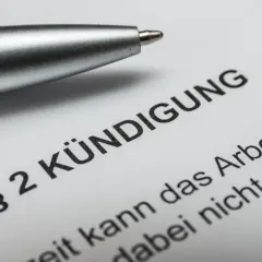Stift liegt auf Dokument mit "Kündigung". Nach 10 Jahren im Job ist die Abfindung ein wichtiges Thema.