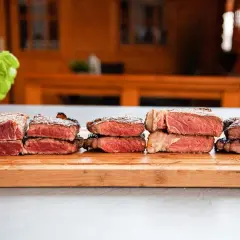 Sechs gestapelte Steaks zeigen verschiedene steak garstufen, von blutig bis medium.