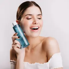 Mujer sonriente con botella de colonia blue Mercadona.