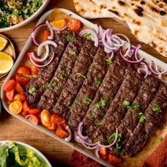 Kebab z mięsa mielonego, pomidorkami, cebulą i pieczywem.