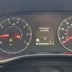 Dacia Sandero: kontrolki informują o braku widoczności kamery przedniej. Widoczne kontrolki hamulca ręcznego, ABS i ciśnienia w oponach.