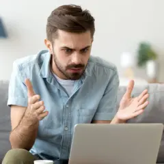 Homme perplexe devant son ordinateur, découvrant une augmentation Deezer inattendue.