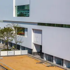 Nowoczesny budynek muzeum sztuki współczesnej w Warszawie, z białymi, geometrycznymi fasadami i dużymi oknami.