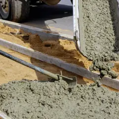 Wylewanie świeżego betonu z betoniarki na plac budowy.