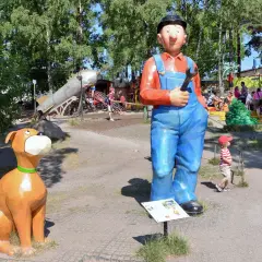 En stor staty av en mekaniker och en hund välkomnar besökare till lekparker i Stockholm.