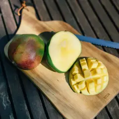 Süße, saftige Mangostücke auf einem Holztisch. Die Frage "ist mango gesund" wird durch diese leckere Frucht beantwortet.
