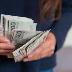 Ręce liczą banknoty 100 zł. To darowizna od rodziców na nowy cel.