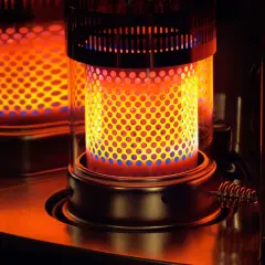Estufa de parafina encendida, con llama naranja y azul. Considera sus pros y contras para calentar tu hogar.