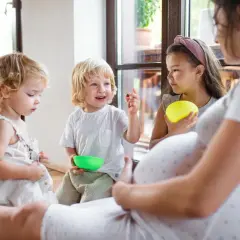Ciąża mamy i trójka dzieci bawiących się w domu. Wesoła rodzina wielodzietna.