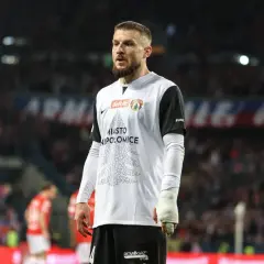 Piłkarz w koszulce z napisem "Miasto Niepołomice" na tle trybun. Przebieg: Wisła Kraków – Puszcza Niepołomice.