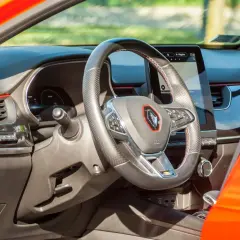 Nowoczesne renault arkana wnętrze z ekranem multimedialnym i kierownicą obszytą skórą. Czerwone akcenty dodają sportowego charakteru.