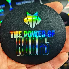 Okrągły czarny naklejka z holograficznym logo i napisem "THE POWER OF ROOFS".