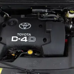 Silnik D-4D w Toyocie Avensis T25. Widoczna czarna pokrywa silnika z logo Toyoty i napisem D-4D.