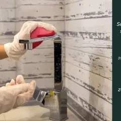 Ręce w rękawiczkach czyszczą kran gąbką. Soda oczyszczona to świetny środek do czyszczenia rur z tłuszczu.