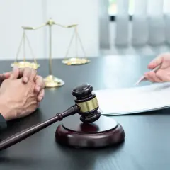 Zstępny kto to? Sędzia i klient przy stole z wagą sprawiedliwości i młotkiem.