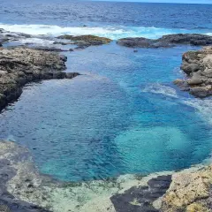 Charcones naturales de Lanzarote, piscinas de agua cristalina entre rocas volcánicas y el azul intenso del océano Atlántico.