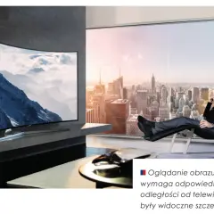 Mężczyzna relaksuje się w fotelu, oglądając krajobraz górski na zakrzywionym ekranie telewizora 16:9. Za nim rozciąga się panorama miasta.