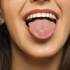 Bocca aperta con lingua fuori, un sorriso che promette un sapore dolce in bocca.