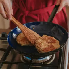 Bratlinge in blauer Emaillepfanne. Die Vorteile einer Emaillepfanne sind ihre Langlebigkeit und einfache Reinigung.