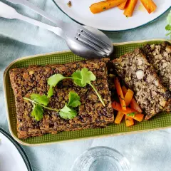 Herzhaftes Linsen-Nuss-Brot mit glasierten Karotten – ein köstliches vegetarisches Weihnachtsessen, garniert mit frischer Petersilie.