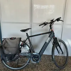 Zwarte Sparta Ion E Speed 2016 e-bike met dubbele fietstassen, klaar voor een rit.