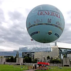 Ballon dirigeable "Générali" survolant Paris, avec la Mairie de Paris et Air Parif inscrits sur sa surface.
