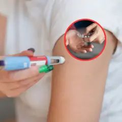 Dłoń z pisakiem do iniekcji i blister z tabletkami w kółku.