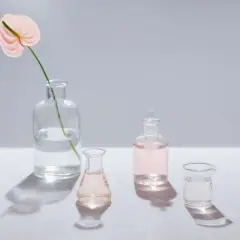 Różowa anturium w wazonie i szklane naczynia z płynami. Czy benzyl alcohol czy jest szkodliwy?