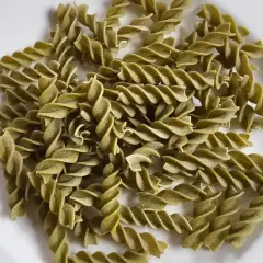 Zielony makaron fusilli z zielonego groszku, ułożony na białym talerzu. Idealny do lekkiego i zdrowego posiłku.