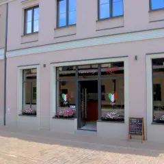 Elegancka fasada restauracji Roma z neonowym napisem i sercami w barwach Włoch.