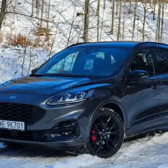 Ford Kuga usterka silnika brak mocy. Ciemnoszary SUV stoi w zimowym lesie, na śniegu.