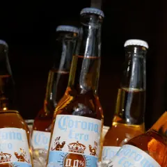 Kilka butelek piwa Corona Cero w wiaderku z lodem. Idealne na upalny dzień, to piwo na c jest orzeźwiające i bezalkoholowe.