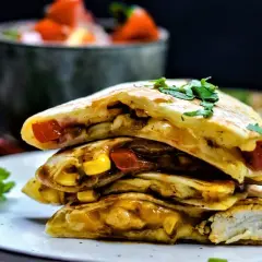 Gestapelte Quesadillas mit Hähnchen, Mais und Tomaten, garniert mit Koriander. So sieht eine leckere Quesadilla aus!