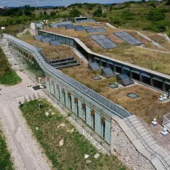 Nowoczesny obiekt z zielonym dachem i przeszklonymi ścianami, idealny na kielce atrakcje dla dorosłych.