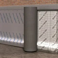 Eine Noppenbahn schützt die Hauswand vor Feuchtigkeit. Sie ist an der Ziegelwand befestigt.