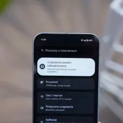 Ekran telefonu z powiadomieniem o aktualizacji systemu. Widoczne ikony sieci 5G i baterii, a także menu Ustawień z opcjami Sieć i internet, Połączone urządzenia i Aplikacje, typowe dla systemu android 16.
