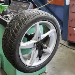 Koło 235/45 R18 na wyważarce. Zastanawiasz się, jakie ciśnienie w oponach 225/45 R18? Sprawdź instrukcję pojazdu.