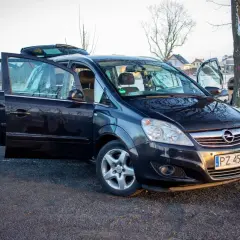 Czarny Opel Zafira B z otwartymi drzwiami, prezentujący różne wersje wyposażenia.