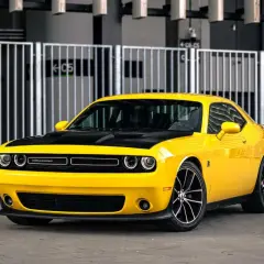 Żółty Dodge Challenger z czarną maską, idealny na letnie przejażdżki. Sprawdź jego atrakcyjną dodge challenger cena!