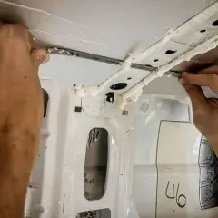 Application de mousse isolante sur la structure intérieure d'un fourgon, étape clé du plan camping-car.