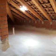Sottotetto in fase di isolamento con schiuma espansa. Si vede la struttura in legno e mattoni, segno che conviene isolare il sottotetto per un maggiore comfort.
