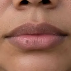 Un pequeño lunar en el labio inferior, como si hubiera aparecido de repente.