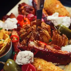 Talerz pełen pyszności: żeberka, skrzydełka, nachos i chrupiąca cebula. Idealna uczta, którą znajdziesz w najlepszych restauracjach w Sopocie.