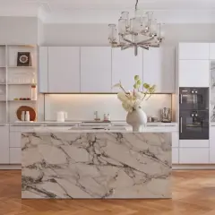 Elegancka kuchnia glamour z marmurową wyspą, białymi frontami i efektownym żyrandolem.